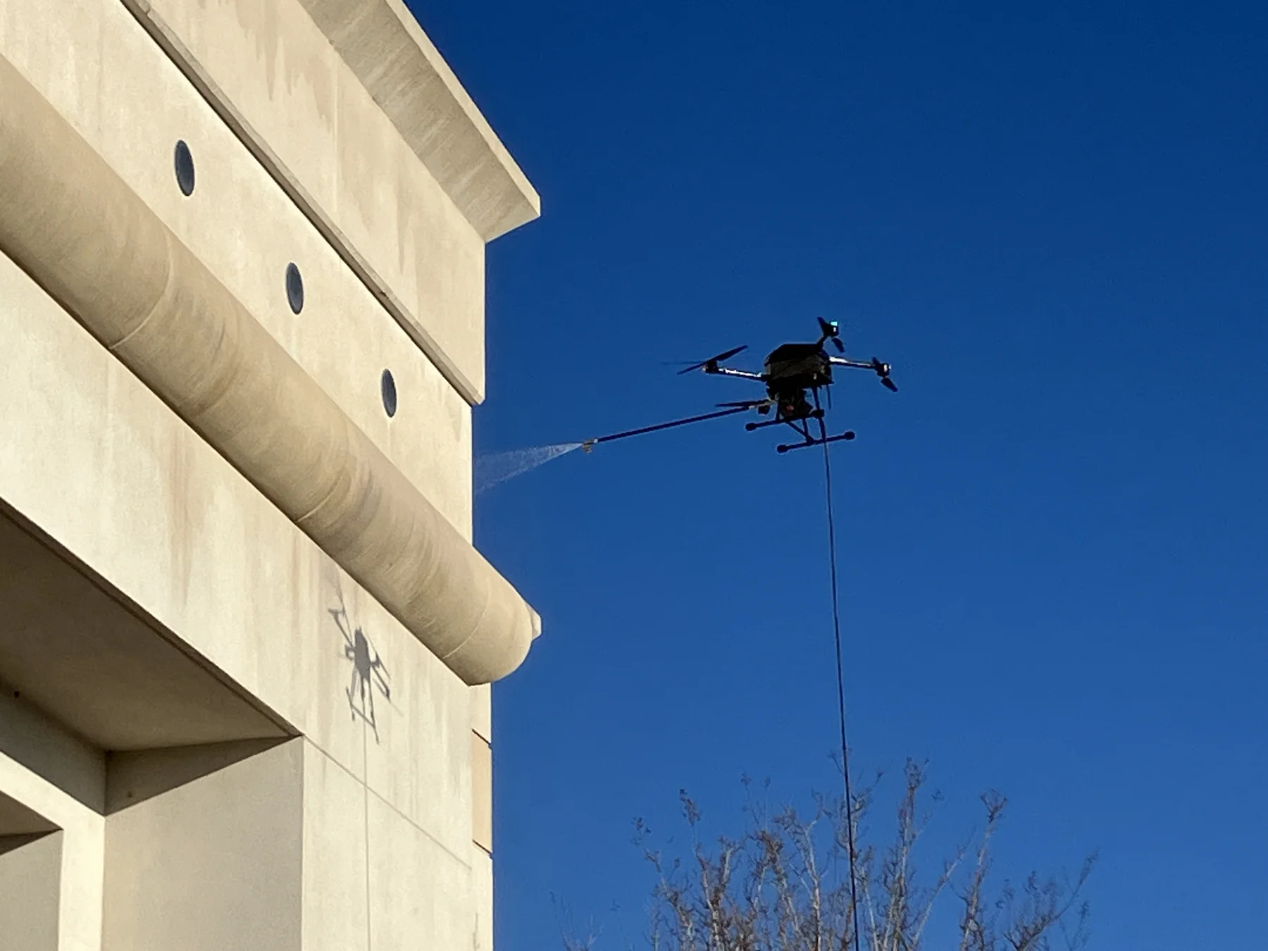 Close view of the commercial washing drone beside an exterior wall