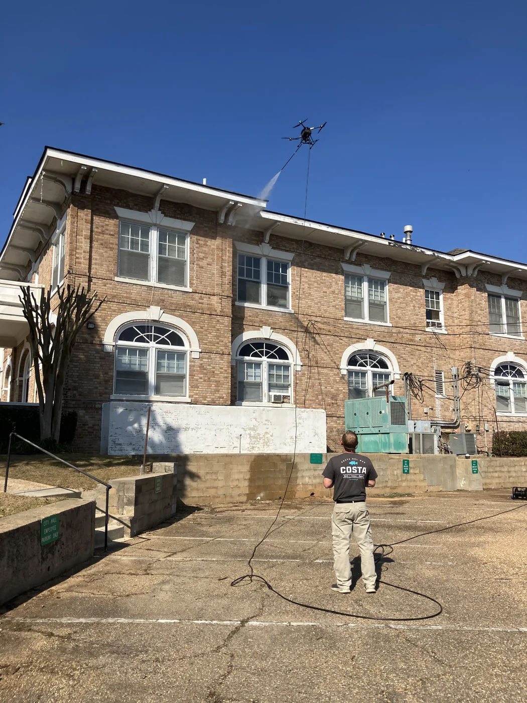 Appleton crew member and equipment outside a brick commercial building